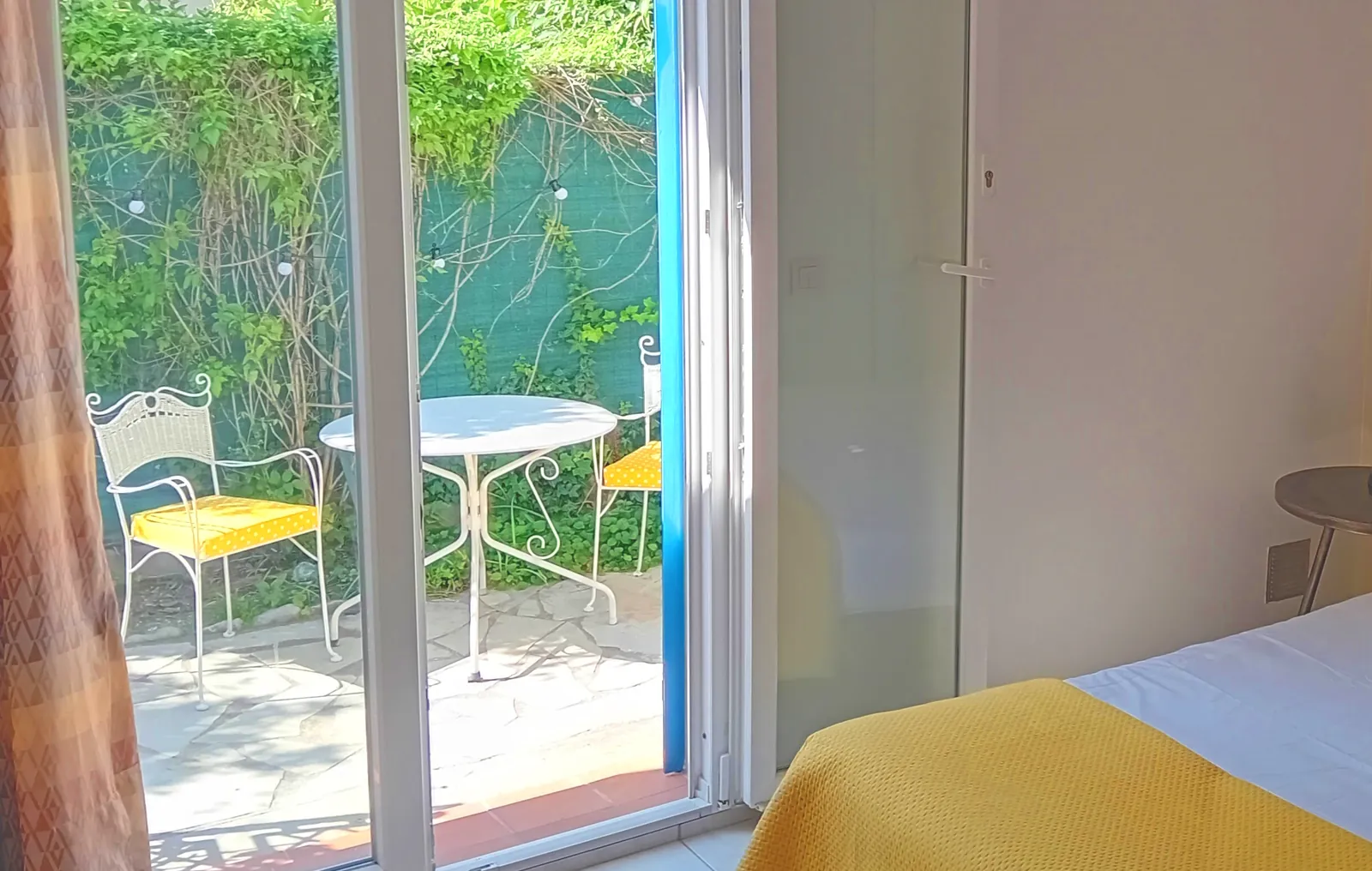Studio Citron : lit double et porte-fenêtre sur la terrasse
