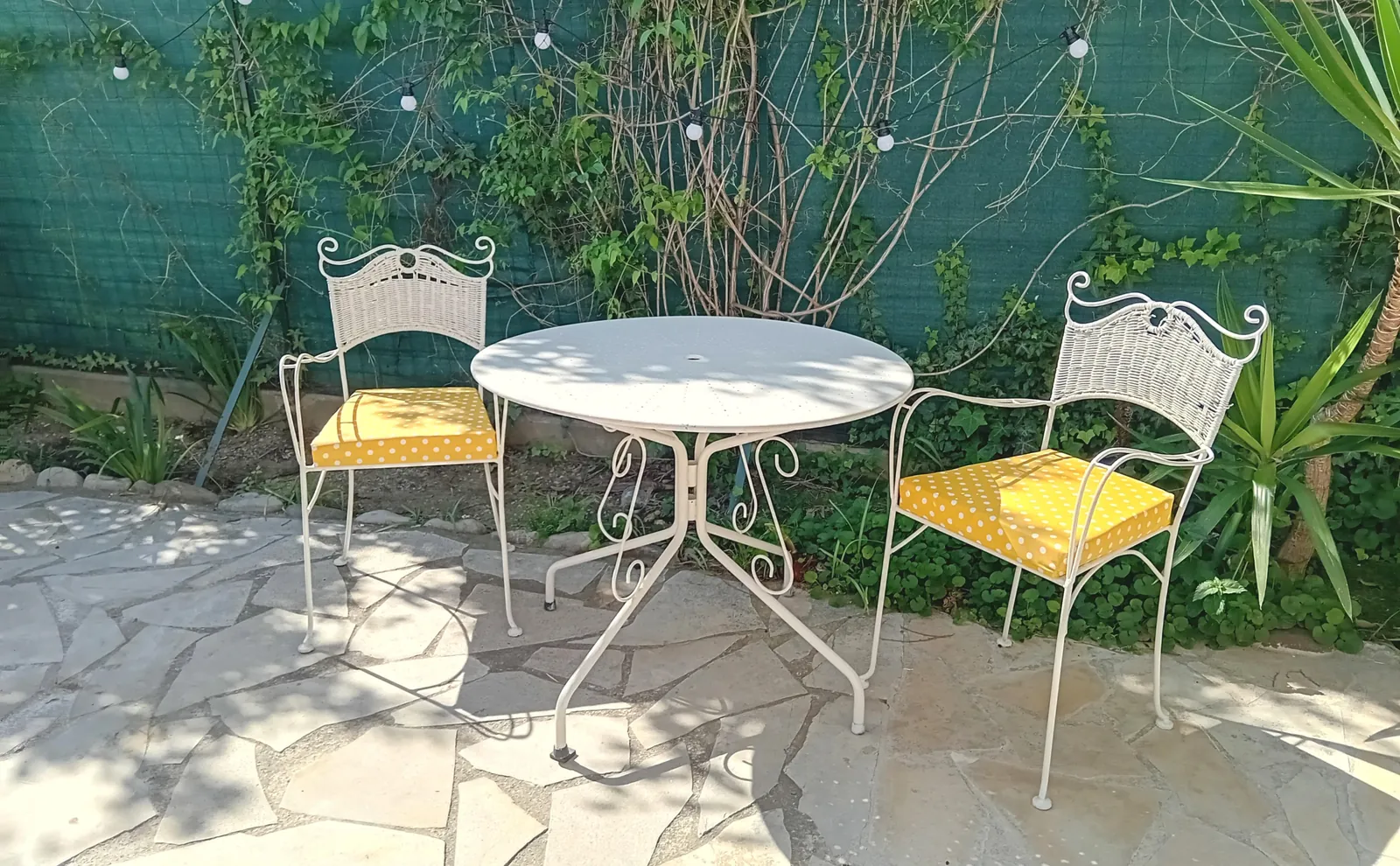 Table et chaises jaunes sur la terrasse commune